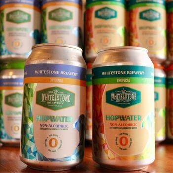 A picture of Ryan and Danielle Anglen holding cans of Whitestone HopWater